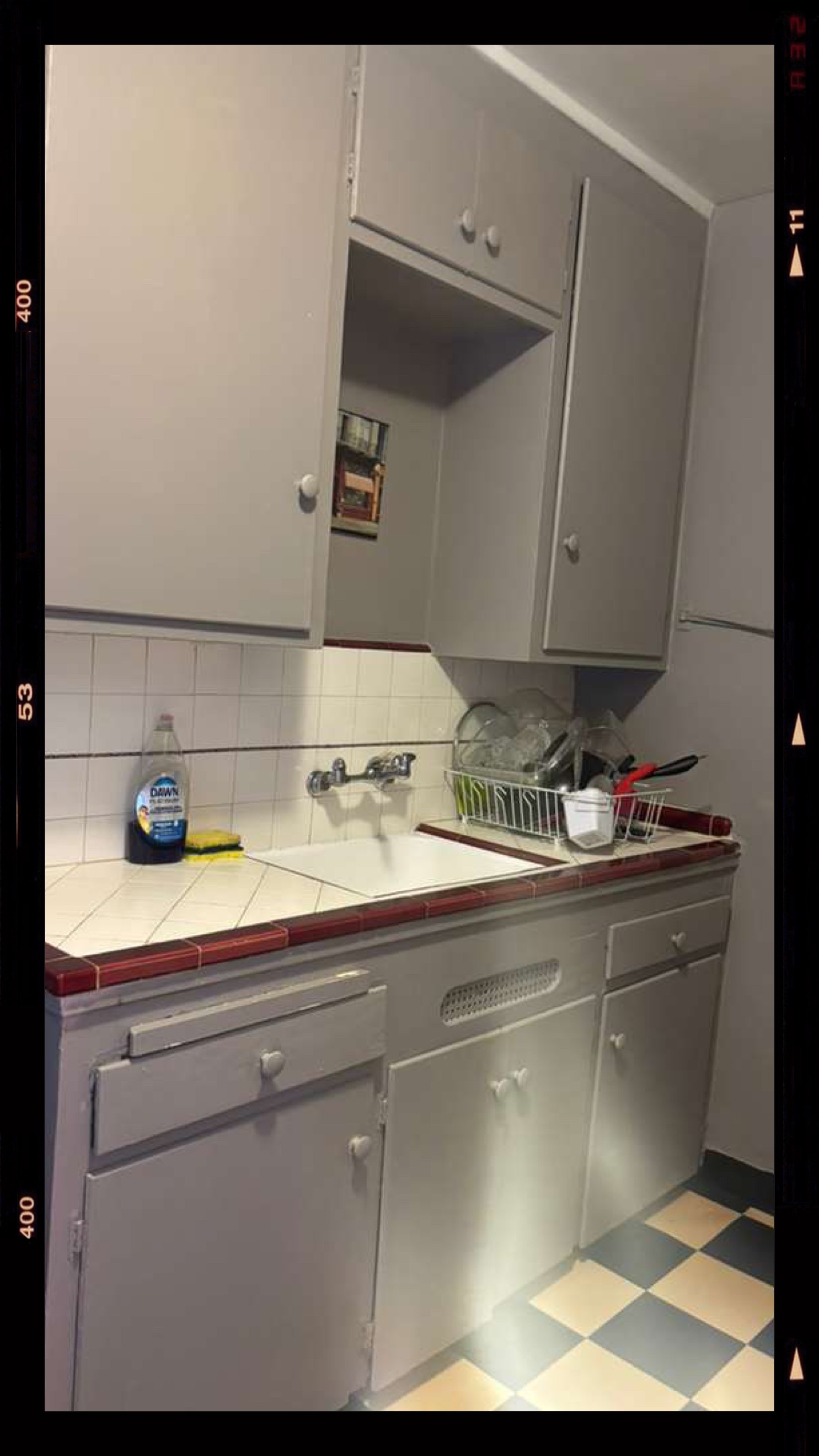 Clean kitchen with white tile backsplash, organized dish rack, and spotless countertops after move out cleaning